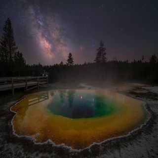 The Milky Way photographed over the morning hot spring in Yellowstone National Park, USA